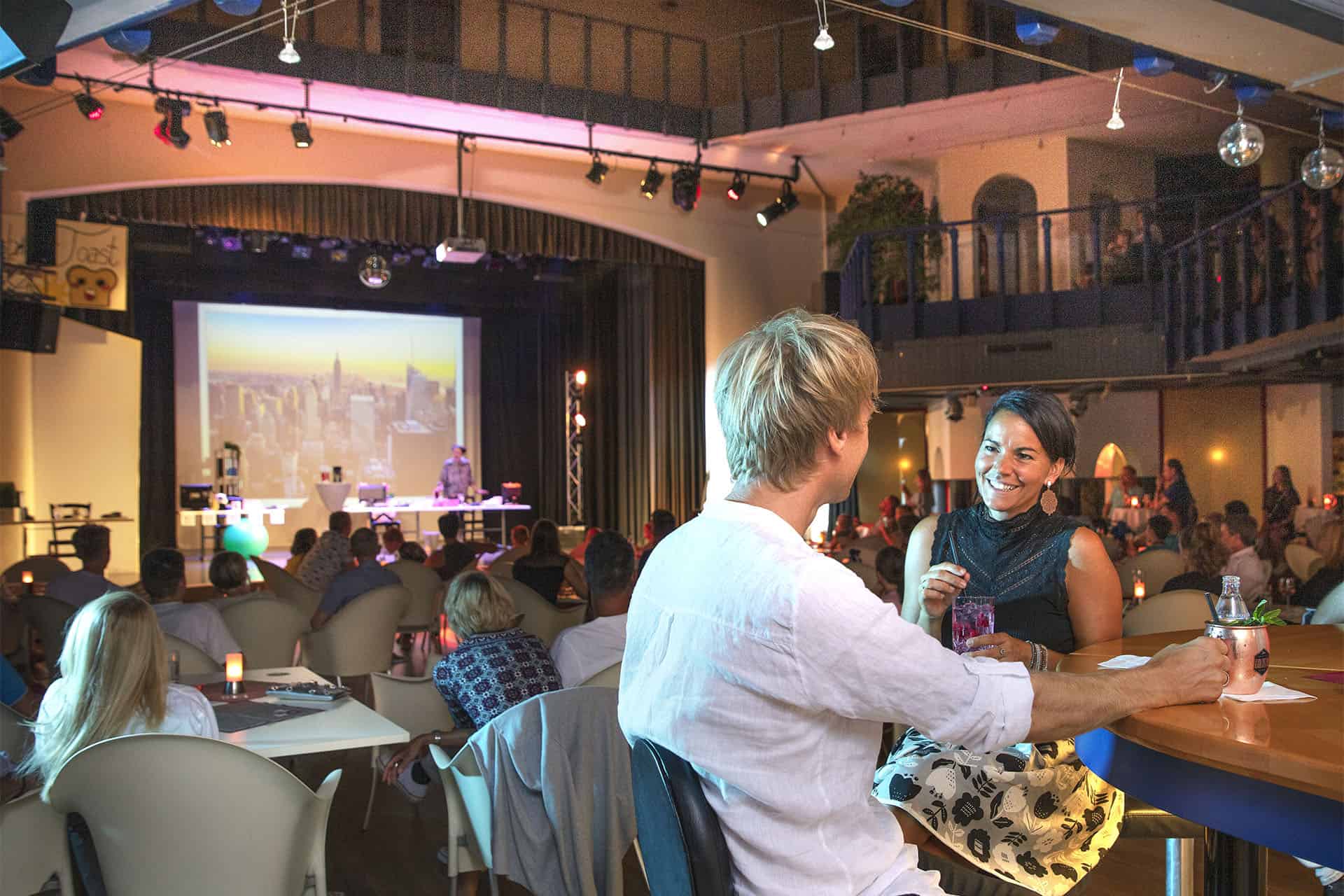 Pärchen an der Hotelbar im Hintergrund Bühne mit einer Live-Show